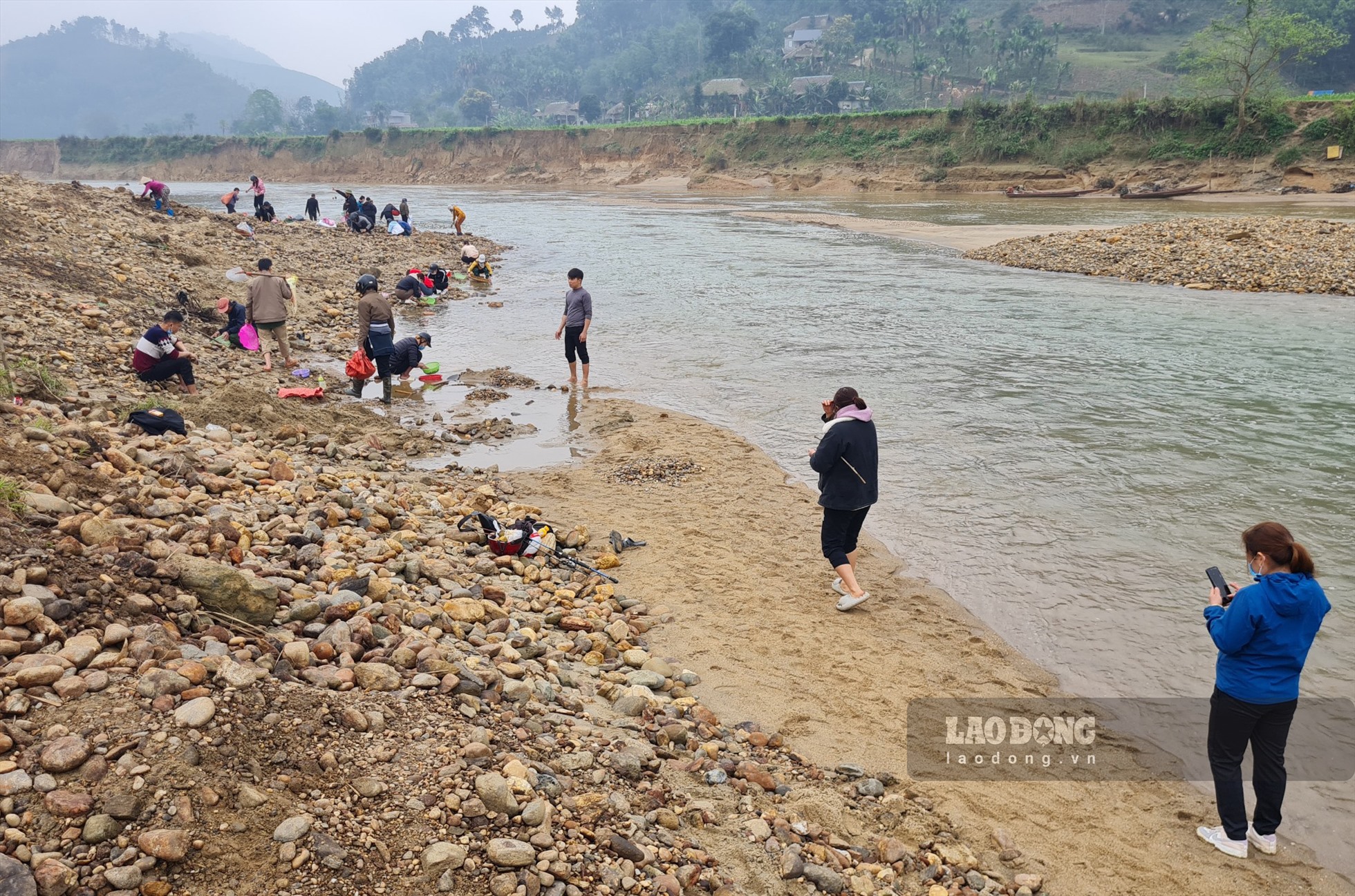 Trên bãi cát, hàng trăm người đang tập trung, có người sàng, đãi cát; người thì đào xới, vận chuyển...như một đại công trường vô cùng nhộn nhịp.